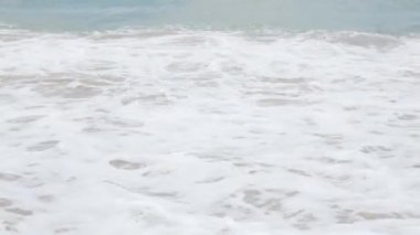 Tayland 'da Phuket Phanga Plajı' ndaki sahil şeridine çarpan köpüklü kumsal, köpüklü kumsal ve köpüklü dalgalar ile beyaz kumsala vururken deniz suyu dalgalarına bakın..
