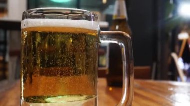 Bardakta altın biranın içindeki baloncuk manzarası, restoranda bir bardak altın bira