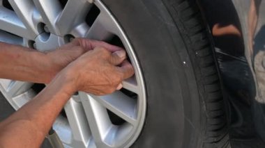 Güneşli bir günde sürücü arabanın lastiğini şişirirken arabanın lastiğini kapat. Hava basıncı göstergesiyle el ele tutuşan ve arabanın lastiğini nitrojen havasıyla dolduran tamirci lastik basıncını kontrol ediyor..