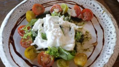 İtalyan usulü salata yemek için çatal ve bıçak kullanıyoruz. Üstünde ev yapımı mozzarella peyniri var. Akşam yemeği için aperatif olarak.