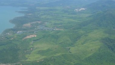 Güneşli bir günde, yeşil alan tropikal iklim ormanı üzerinde uçarken yeşil arazi üzerinde tarlalar ve ormanlarla uçarken hava manzarası.