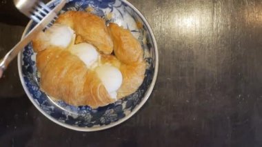 Asgari kafede çatal ve bıçak kullanarak tabakta dondurmalı sandviç keserken, tabakta tatlı yerken manzarayı seyret.