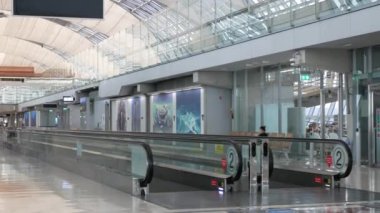Havaalanı kalkış terminalinin iç görüntüsü. Yürüme yürüyen merdiven var, terminalde yolcu yok, havaalanı seyahat terminali arka planı var.