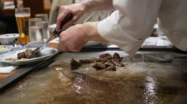Japon şef wagyu Kobe biftek sulu et dilimlerken Japon restoranında ızgara et Japon usulü mermer bifteği servis etmeye hazırlanıyor.