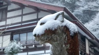 Japonya 'nın Kyoto kırsalındaki tapınağın önündeki kaplan heykeli heykeli. Kış mevsiminde heykele buz gibi kar yağarken Japon mimarisi kışın kar yağdığında dizayn ediliyor.