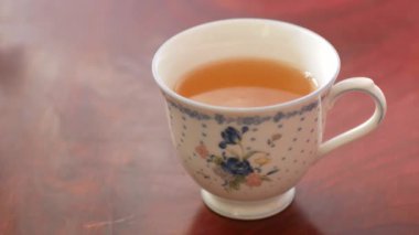 Öğleden sonra çay saatinde ahşap masadan çay içerken bir fincan çay içerken, evde sıcak çay içerken, dinlenme zamanı.