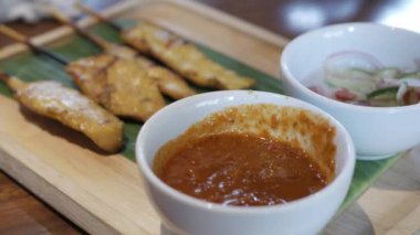 Geleneksel tekil ya da Malezya usulü bir tabakta satay şiş tavuk yemek ya da atıştırmalıktan önce aperatif olarak sosa batırılır.