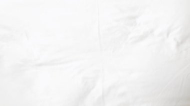 Asyalı erkek temizlik odası makyaj odasını düzenliyor yatak odasındaki beyaz keten yatağa havlu yerleştiriyor, yatak odasındaki yatağın üzerine beyaz kule kuruyor misafirler için otel odası hazırlıyor.