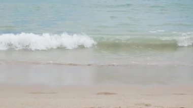 Tayland 'da Phuket Phanga Plajı' ndaki sahil şeridine çarpan köpüklü kumsal, köpüklü kumsal ve köpüklü dalgalar ile beyaz kumsala vururken deniz suyu dalgalarına bakın..