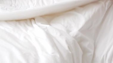 Sabahları yatak odasında yatak örtüsü ve yastık hazırlayan bir adam otel odasında makyaj yaparken beyaz çarşaf beyazı yatak manzarası.
