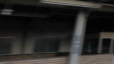 Kamu metro treninin penceresinden Osaka şehrinde kışın dışarıdaki konut ve ofis binalarını izlerken hızlı hareket ediyorlar.