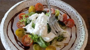 İtalyan usulü salata yemek için çatal ve bıçak kullanıyoruz. Üstünde ev yapımı mozzarella peyniri var. Akşam yemeği için aperatif olarak.