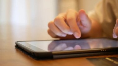 Bir elin adamının dijital tablet mobil ekranına dokunarak internette sosyal medya veya evde online alışveriş arayışını kapatması, tablet üzerinden evden online alışveriş yapması