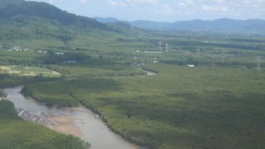 Phuket havaalanına yaklaşan uçak penceresinden hava görüntüsü Phuket 'in yeşil doğal alanı üzerinde güneşli tatil gününde karayolu manzaralı.