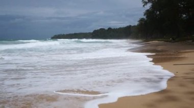 Phuket 'teki beyaz deniz kumlu sahile vuran güçlü dalgalarla deniz kıyısı manzaralı tropikal seyahat tatili yağmurlu, bulutlu, sert rüzgarlı strom geliyor.