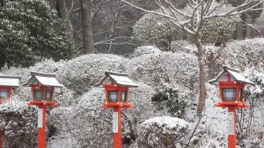 Japonya 'nın Kyoto Dağı Kurama tapınağındaki kayalık merdiven yolu boyunca geleneksel ahşap fenere kar yağıyor. Kışın şiddetli kar yağan eski Budizm mimari binası