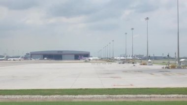 Şubat 12.2024.Bangkok, Tayland. Havaalanı terminalinde çalışan birçok uçağın park alanının bulunduğu Suvarnabhumi havaalanında taksicilik yapan uçak penceresinden görülüyor.