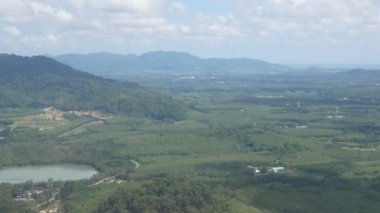 Phuket havaalanına yaklaşan uçak penceresinden hava görüntüsü Phuket 'in yeşil doğal alanı üzerinde güneşli tatil gününde karayolu manzaralı.