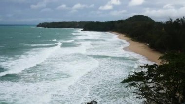 Deniz kumu sahil koyunun hava manzarası güçlü bir dalga ile Phuket tropikal tatil yerindeki beyaz kumsal sahili vurdu yaz tatilinde ve arka planda dağ aralığı