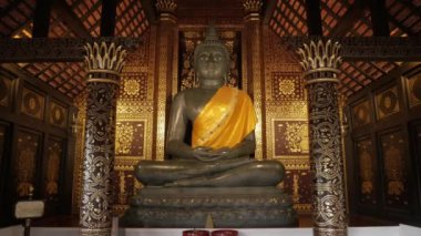 Tayland 'ın kuzeyindeki Budizm Tapınağı' nda ahşap binanın içindeki altın sanat mimarlı büyük Buda heykelinin manzarası.