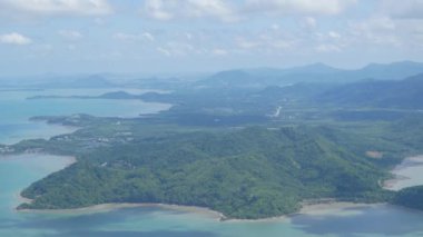 Phuket Adası 'nın deniz sahili manzarası tropikal doğal deniz ceketli uçurum plajı üzerinde güneşli yaz gününde yüksek rakımlı gökyüzünde bulutların ve adaların üzerinden okyanus üzerinden uçuyor.