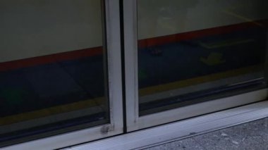 Tren istasyonuna giderken metro peronunun kapısını eğitirken düşük açılı ve seçici odaklı bir bakış açısı var. Halka açık tren ulaşımı. Platform güvenlik kapısına alçak açı görünümü.