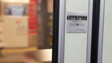Tren istasyonunun arka plan görüşü bulanık bir şekilde metro istasyonundan hızla hareket ederken tren istasyonunun, Japon toplu taşımacılığının içeriden görünüşü de bulanık.