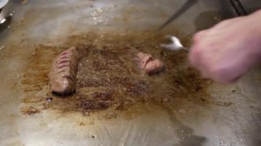Japon şef wagyu Kobe biftek sulu et dilimlerken Japon restoranında ızgara et Japon usulü mermer bifteği servis etmeye hazırlanıyor.