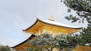 25 Ocak 2024 Kyoto, Japonya. Kinkakuji Altın Pavyonu Japon Zen 'i arasında kışın kar yağarken büyük bir gölete bakan, Kyoto tapınağı, Kış Sahnesi' ne düşen kar.