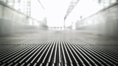 Modern havaalanı terminalinde hareket halindeyken alçak açılı yürüyen merdiven görüntüsü kalkış kapısına yol açar. Metro havaalanı terminalinde elektrikli yürüyen merdiven.