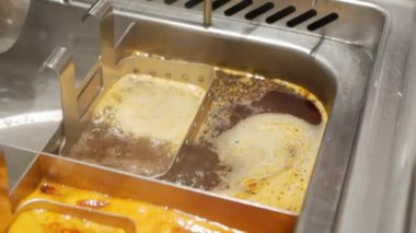 Çin lokantasında Çin usulü sıcak baharat çorbasıyla dolu bir güveç tenceresine yakından bakın. Öğle yemeği için kaynarken Çin usulü Szechuan Mala Shabu restoranı.