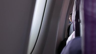 Uçak içinde uçak koltuğunun arka görüntüsü seçici bir şekilde uçarken koltuğa odaklanmış, tatil için uçak kabininin içinde.