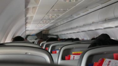 Uçaktaki yolcu koltuğunun arka görüntüsü seçici bir şekilde koltuğa odaklanmış yolcu koltuğunda dinleniyor, tatil için uçak kabininde.