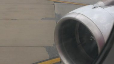 Güneşli bir günde kalkışa hazır bir takside jet motoruyla uçak camından, uçak motorundan uçak penceresinden, tatilde uçak yolculuğunun arka planına bakın.