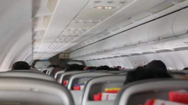Uçaktaki yolcu koltuğunun arka görüntüsü seçici bir şekilde koltuğa odaklanmış yolcu koltuğunda dinleniyor, tatil için uçak kabininde.