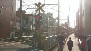 Ekim 23, 2024, Tokyo, Japonya Jiyugaoka 'nın ünlü caddesi. Kalabalık yayalar demiryolu geçidini geçmek için bekliyor. Kalabalık yaya geçidinde dur işareti var.