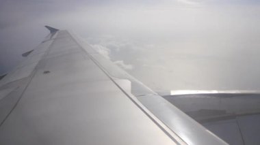 Gün batımında bulutların üzerinde gökyüzüne tırmanırken uçağın içeriden pencereyi seyretmek, doğal ulaşım tatil arka planı.