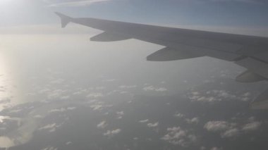 Gün batımında bulutların üzerinde gökyüzüne tırmanırken uçağın içeriden pencereyi seyretmek, doğal ulaşım tatil arka planı.
