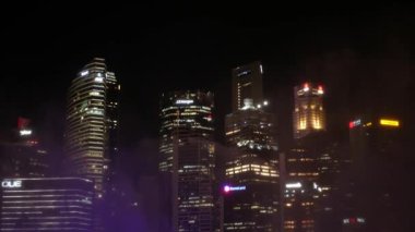 Mayıs 1, 2023. İşletme Bölgesi gökdelenlerinin arka planına sahip Marina Bay Sands 'in önündeki gezinti alanı boyunca ışık ve su ile dans eden fıskiyelerin gösterimi.