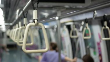 Seçici bir odak noktası ile yakın görünüm metro trenin trabzan tutun şehir toplu taşımacılık. Bir metro içi boş bazı yolcular ile metro trenin içi..