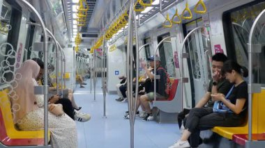 Mayıs 2023.Singapore. Singapur şehrinin metro taşımacılığının iç mekan görüntüsü, trendeki bazı yolcular, iş yeri finans şehri bölgesinin yeraltı tren hizmetleri.