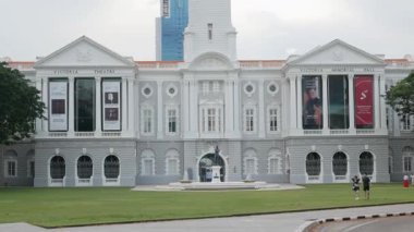 Mayıs 1, 2023. Victoria Tiyatrosu ve Konser Salonu. Sör Stamford Piyango Heykeli ile birlikte Singapur Merkez Bölgesi girişinin önünde. Gündüz vakti yeşil ağaçlar arasında park manzarası.