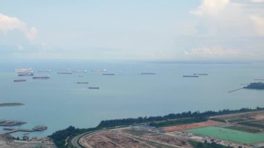 Singapur Körfezi Sahil Limanı 'nın yukarıdan görünüşü uçaktan Singapur havaalanından havalanırken. Singapur limanının gündüz hava görüntüsü ve denizde birçok konteynır yolcu gemisi var.