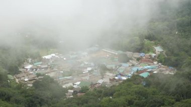 Doi pui 'nin hava manzarası, köyün yerel köyünü gösteriyor. Dağlık tepe vadisinin ortasında, kış günü köyün üzerinde beyaz bulut ve sis var.