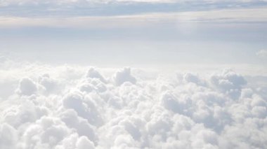 Mavi gökyüzü ve bulutlar bulutların üzerinden uçuyor. Güneşli bir günde, bulutlar yazın bulutların arkasında hareket ediyor.