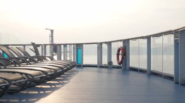 Yaz tatilinde Asya 'da uluslararası açık denizde seyahat ederken yolcu gemisinin güneşli güvertelerinde boş şezlonglar. Yolcu gemisinin balkon güvertesinde güneş şezlongunda