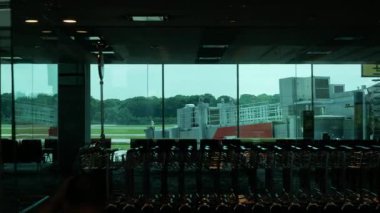 Siluet görüntüsü, uluslararası havaalanında uçakla birlikte havaalanı manzaralı yürüyüş yolunda ilerlerken, kalkış terminali içinde. Seyahat tatili başlangıç zamanı