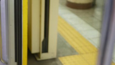 Tren metrosunun metro metro kapısının seçici odak noktası. Kapı kapanıyor ve tren istasyon peronundan kalkıyor. Japon toplu tren ulaşımı.