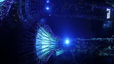23.2022.Singapore. Süperağaç modern mimari ağaç tasarımına dikey bir bakış açısıyla ışık altında Singapur 'daki ünlü Bay durağı Garden' da performans gösterirken ışık altında