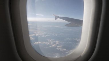Gün batımında bulutların üzerinde gökyüzüne tırmanırken uçağın içeriden pencereyi seyretmek, doğal ulaşım tatil arka planı.